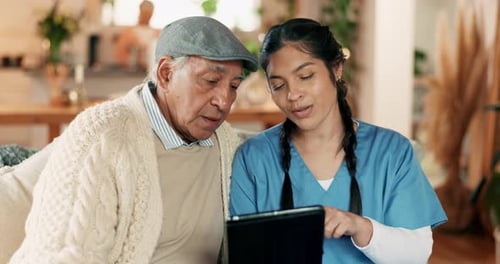 Young Woman Showing Senior Man Tablet in Bright Home