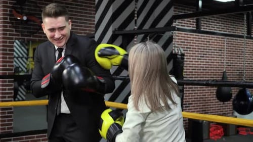 Boss Trains His Employee in Boxing Gloves in the Ring