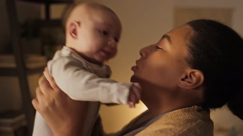 Parent Laughing and Playing with Baby Indoors