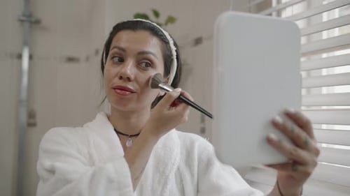 Woman Applying Makeup in a Bright Bathroom