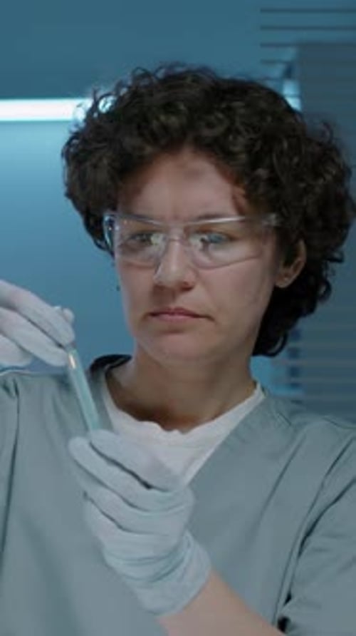 Scientist Mixing a Vial of Blue Liquid
