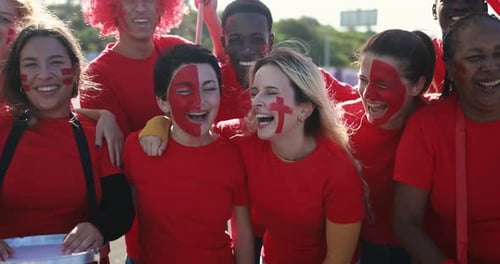 Enthusiastic Fans Cheer with Face Paint and Drum