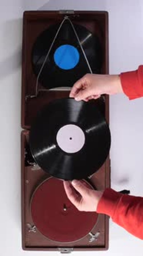 Vertical Video Top View Man Holding a Vinyl Record in His Hands Man Choosing What Music to Listen
