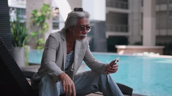 Senior Asian Man Dials a Phone Number on His Smartphone to Make a Call ...