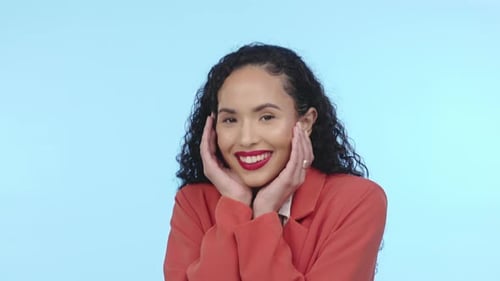 Happiness, excited and face of a woman in isolated, blue background and studio