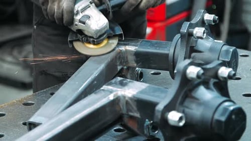 Worker Processing Place of Welding Metal Square Pipes by Angle Grinder. Technical