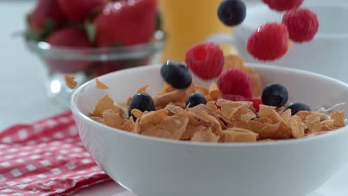 Blueberries and raspberries falling into breakfast cereal in slow motion phantom flex 4k