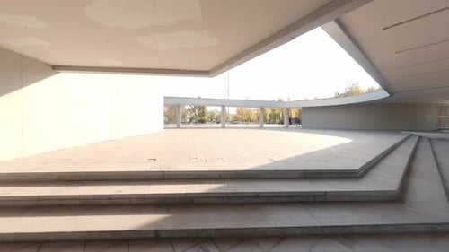 FPV drone view of Guys are skating on the square next to the modern building 16