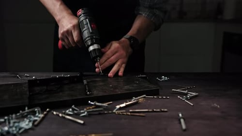 Furniture Carpenter Drilling Black Wooden Planks In Workshop