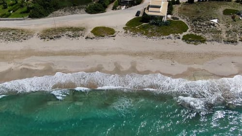 Aerial Top-Down Drone Shot Tracking Sideways along Coastline, Showing Villas, Pool, Sandy Beach, and