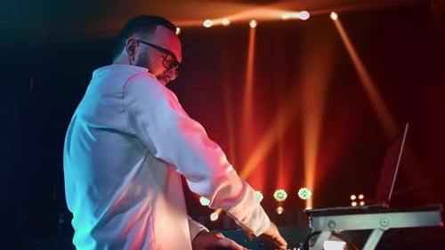 Man Mixing Music on Soundboard in Nightclub