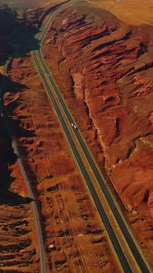 Rocky orange landscape crossed by the motorways with few cars moving by.