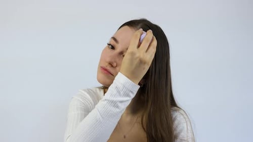 Woman Applying Foundation with Brush on Face