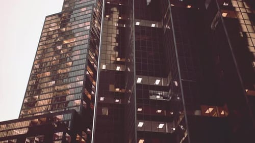 Un rascacielos imponente con una serie de ventanas que iluminan el horizonte de la ciudad