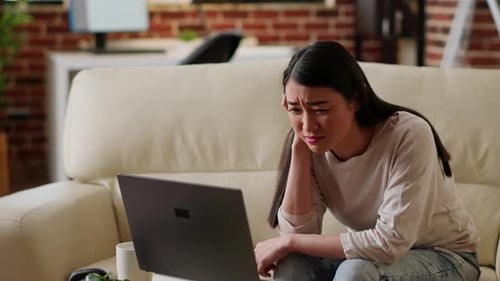Stressed Woman Working Remotely on Laptop While Trying to Understand Job Assignment