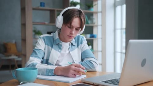 Teen Boy Studying, Wearing Headphones Indoors