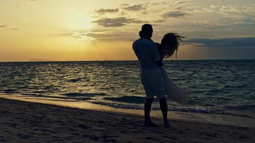 Romantic Couple Twirling Around on a Sunset Beach Slow Motion