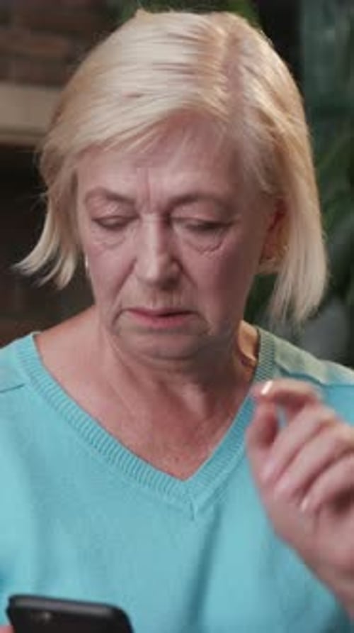An Elderly Woman Deeply Engaged with Her Smartphone in a Modern and Stylish Setting