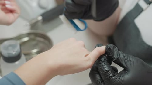 Nail Technician Filing Client's Nails in Beauty Salon