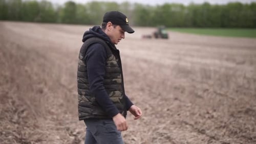 farmer watching his tractor planting sunflower at the field