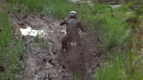Muddy Dirt Bike Rider Racing in the Countryside