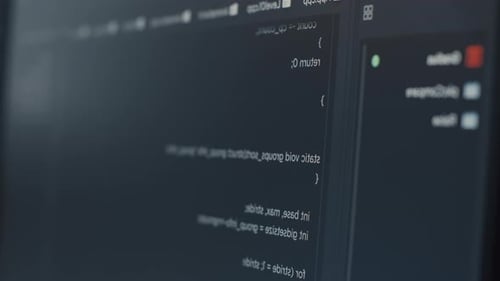 Close-Up of Mirrored Computer Code on a Dark Screen