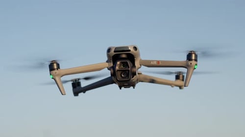 Close-up of DJI Air 3 drone in mid-flight against clear sky during daylight