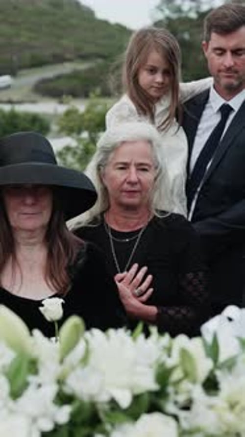 Death, grief and family at funeral in cemetery, mourning together and view casket for remembrance