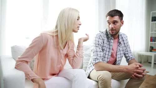 Attractive couple on couch having a serious discussion