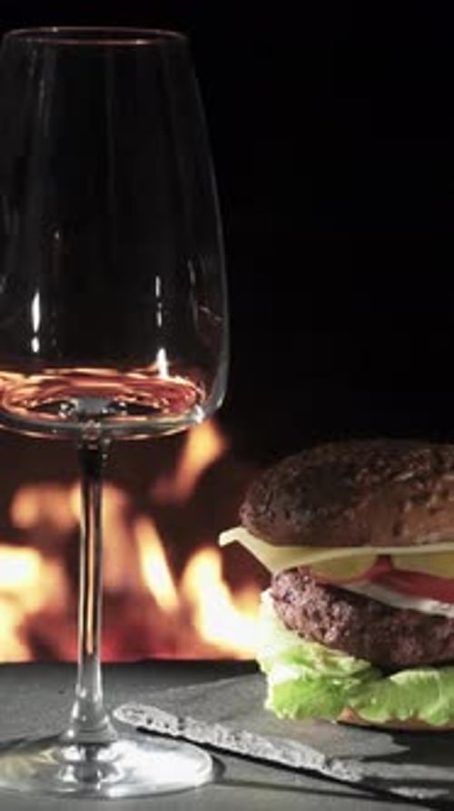 A burger in the background and an empty wine bar against the background of the fire. On a stone tray