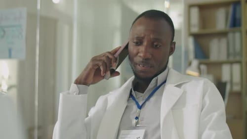 African American Doctor Having Phone Talk in Clinic