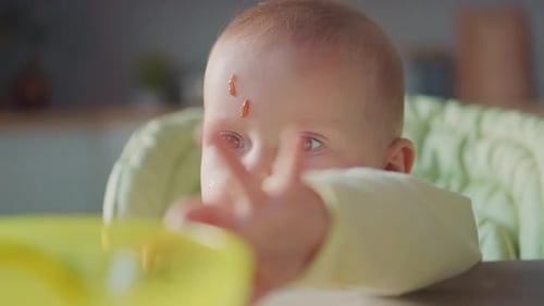 Close-up of messy infant in high chair