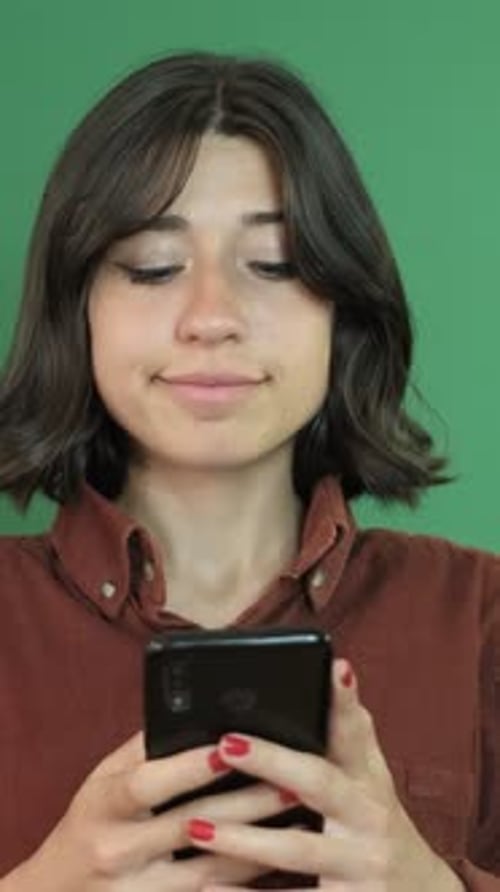 Young Woman Thoughtful With Smartphone on Green Screen