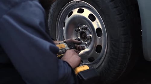 Mechanic Tightening Lug Nuts with Power Tool
