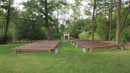Smooth gimbal entering empty outdoor forest wedding ceremony arrangement with wooden chairs