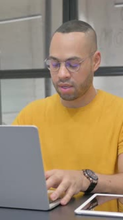 Excited Hispanic Man Celebrating Success on Laptop in Office, vertical video