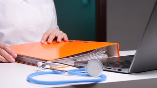 Medical Worker Reviewing Documents on Desk