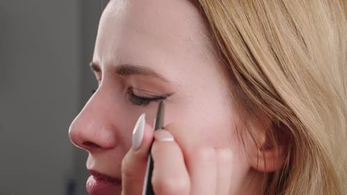 Woman Applies Eyeliner in Close Up Shot