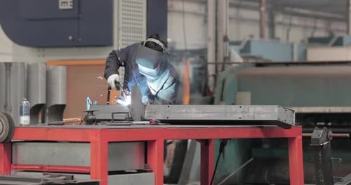 Soudeur qualifié travaillant sur la fabrication de métaux dans une usine industrielle très fréquentée