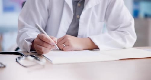 Médecin rédigeant une ordonnance ou un diagnostic lors de la consultation
