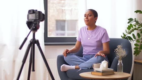 Glückliche afroamerikanische Videobloggerin, die zu Hause Inhalte erstellt