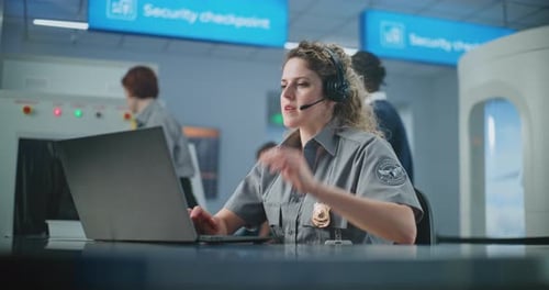 Airport Security Checkpoint Female Security Officer Talking on Headset Using Laptop Computer
