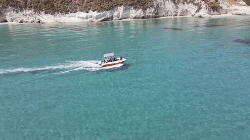Chasing the boat ont the water with turquoise clear water in Zakynthos Greece.