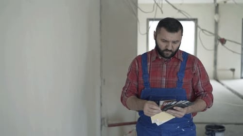 Construction Worker Choosing Paint Colors in New Home