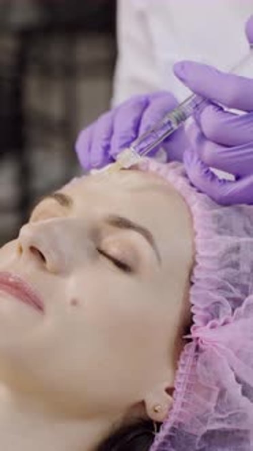 Woman Receiving Cosmetic Injection Treatment on Forehead