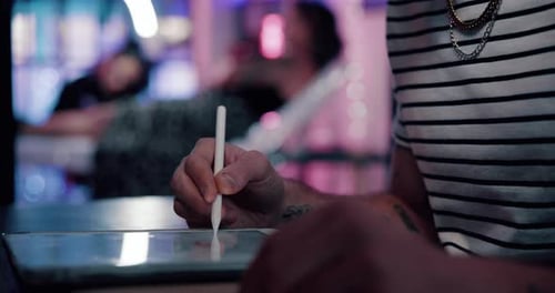 Close up of person using stylus on tablet
