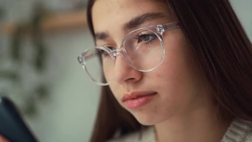 Close up of caucasian teenage girl browsing phone in her room. Shot with RED helium camera in 8K.