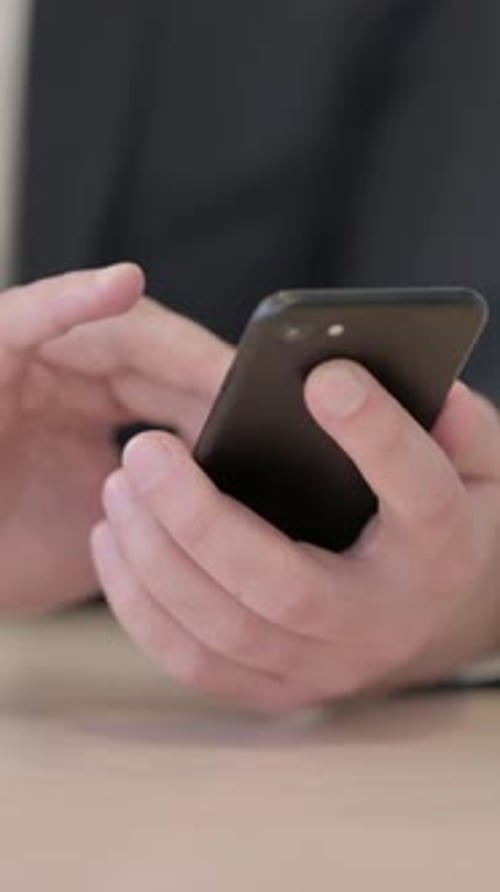 Close up of Businessman Browsing Internet on Smartphone, vertical video
