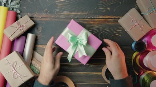 Gift Wrapper Man Hands Beautifully Gives It to Woman Top View Receiving Pink Presents