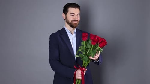St. Valentine's Day. Man with bouquet of roses on grey background